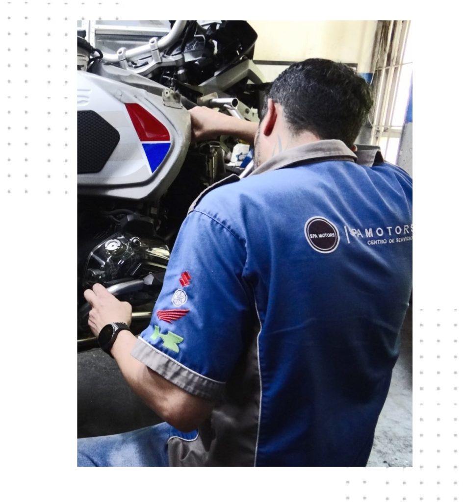 Mecánico de spamotors haciendo servicios técnicos a una moto